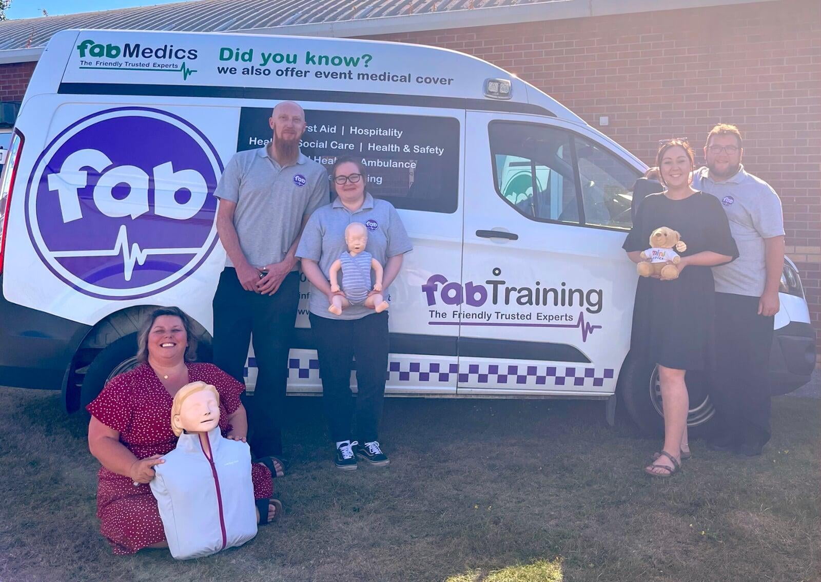 Our team stood in front of our company vehicle smiling and showing off our training equipment. 